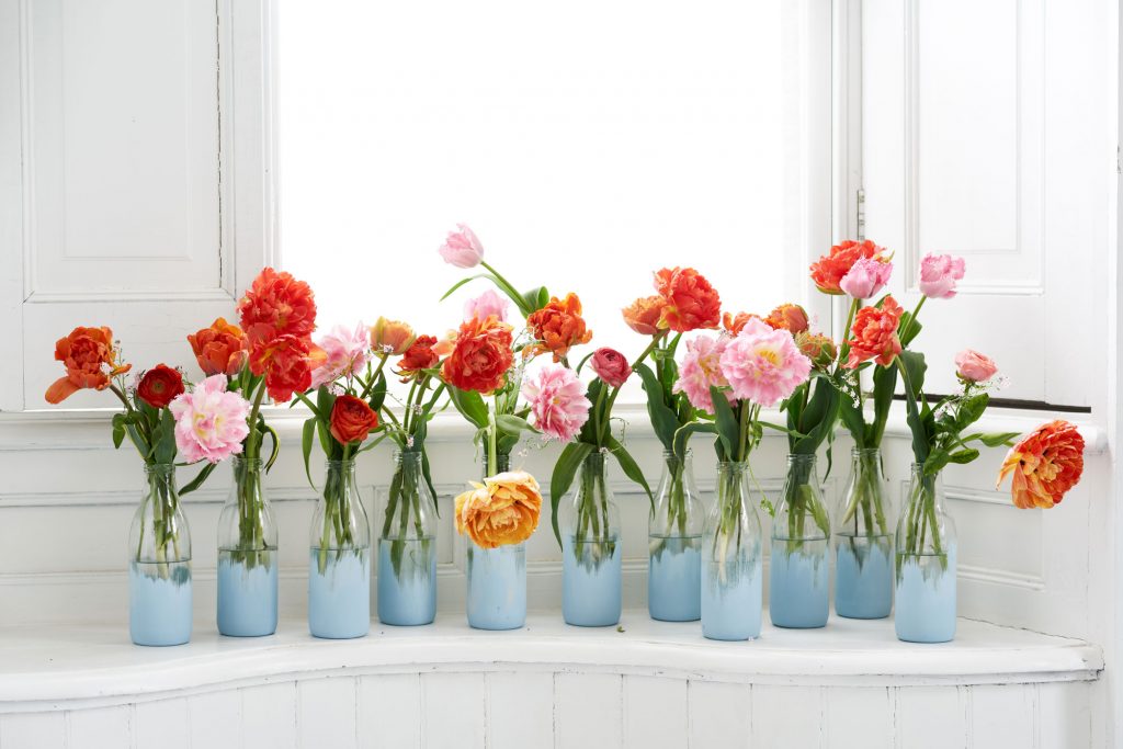 Ein Meer aus roten, orangenen und rosa Tulpen in vielen kleinen Vasen