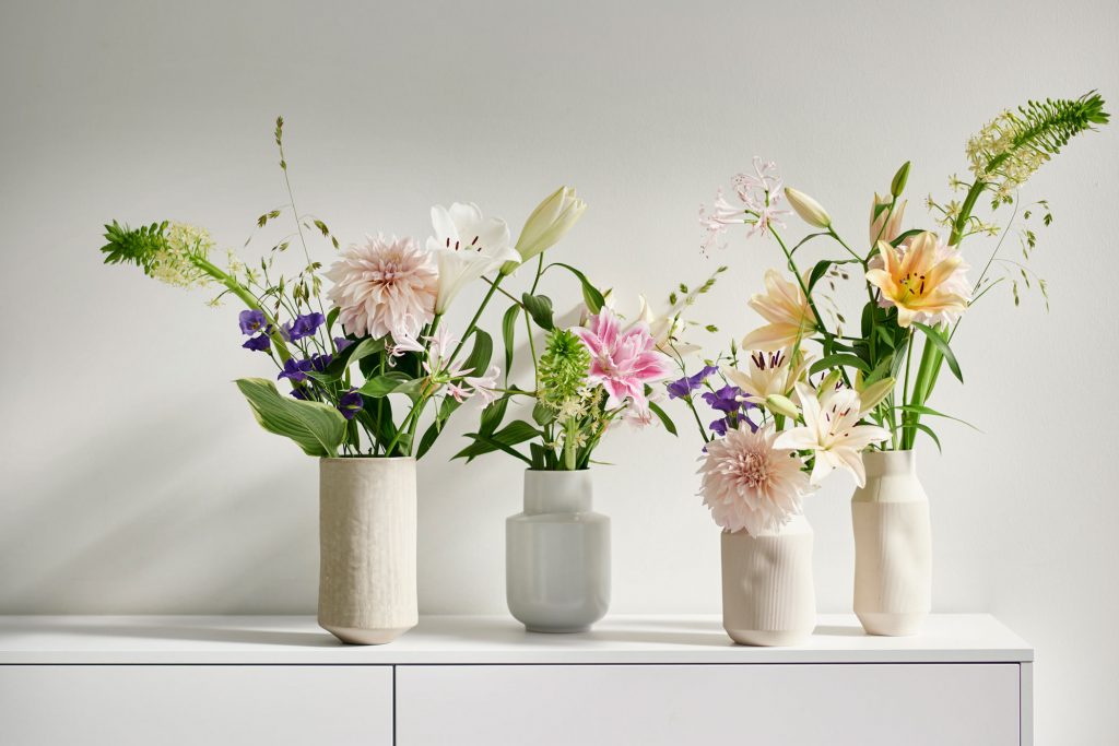 Vier Blumenvasen mit bunten Sträußen
