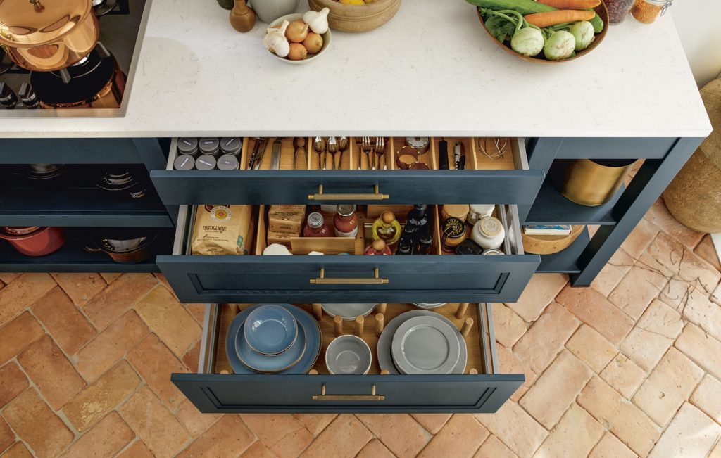 Eine offene Schublade in der Küche zeigt den sortieren Inhalt: Teller, Gewürze und Besteck 