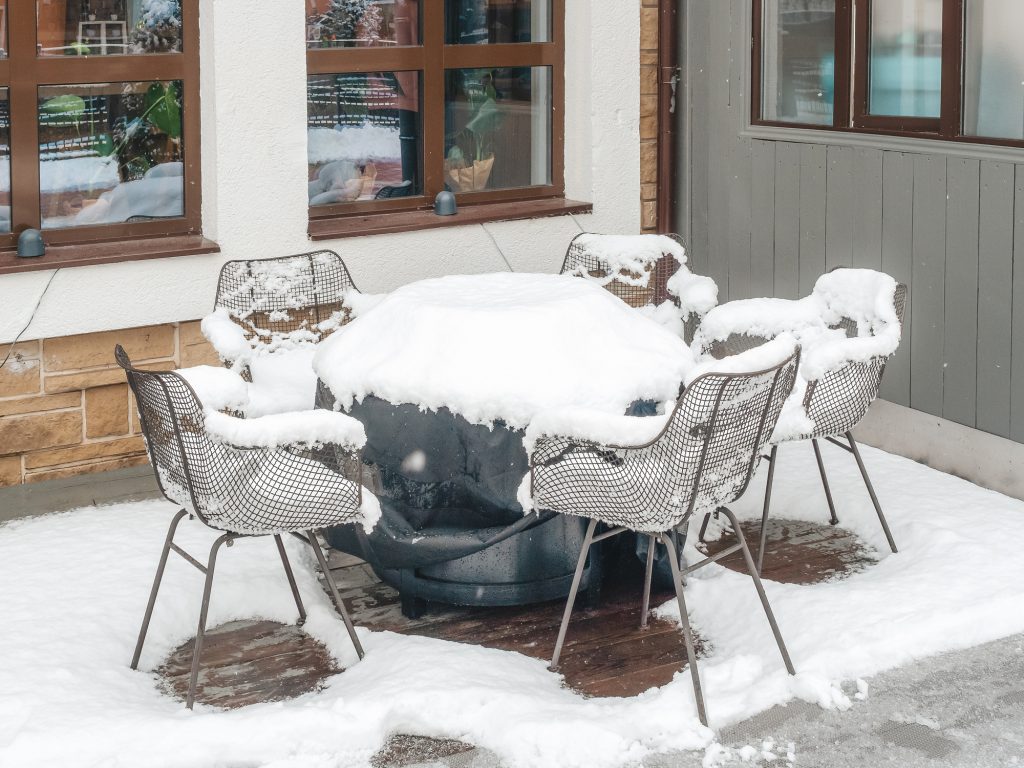 Gartenmöbel, die schutzlos dem Schnee ausgeliefert sind
